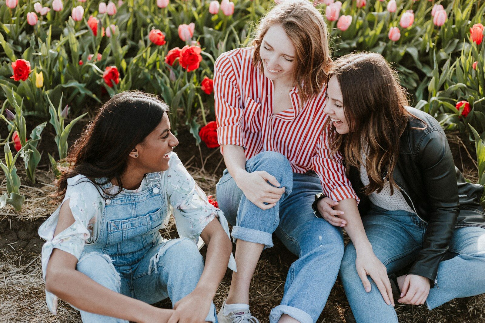 three woman sitting near the flower