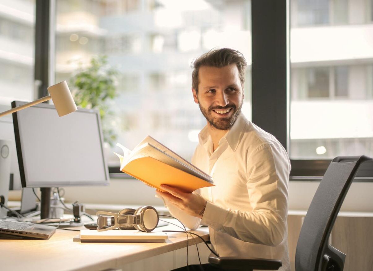 A relaxed businessman enjoying a break in his bright, contemporary office environment.